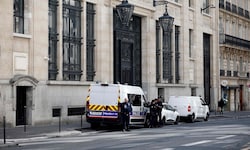 Einsatzkräfte stehen vor dem Gebäude der Filiale der Bank of America in Paris.