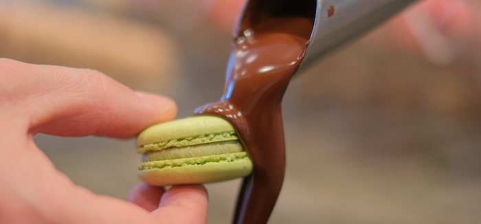 Aus Edelstahlhähnen sprudelt Schokolade.