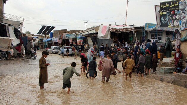 Anwohner waten nach heftigen Regenfällen in Kandahar, der drittgrößten Stadt Afghanistans, durch ...
