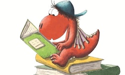 Der kleine Drache Kokosnuss auf einem Bücherstapel