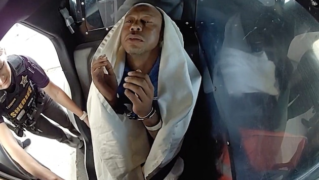 Disturbing sight: Former golf superstar Tiger Woods, dazed and in handcuffs, in a police car ...