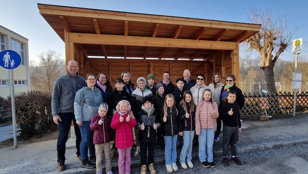 Kinder, Eltern und Stadtchef Franz Fischer (links) freuen sich über das neue große Buswartehaus, ...