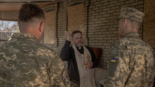 Ein Militärgeistlicher segnet ukrainische Soldaten während des orthodoxen Osterfestes in der ...