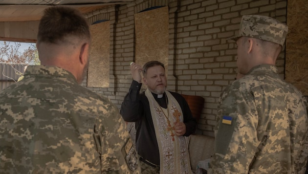 Ein Militärgeistlicher segnet ukrainische Soldaten während des orthodoxen Osterfestes in der ...