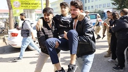 Ein verletzter Schüler wird von helfenden Händen weggebracht.