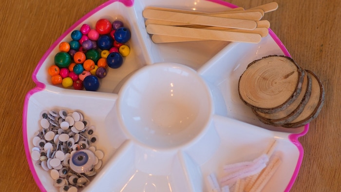 Eisstiele, Holzscheiben, Pfeifenputzer und Perlen sind die Bestandteile der Schnecke.