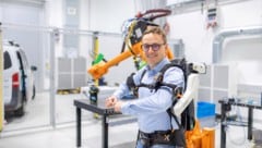 Institutsdirektor Christian Oswald demonstriert ein Exo-Skellett.