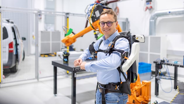 Institutsdirektor Christian Oswald demonstriert ein Exo-Skellett.