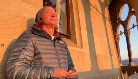 Thomas Bauer, meditierend in der Morgensonne, 68 Meter über dem Treiben der Linzer Altstadt