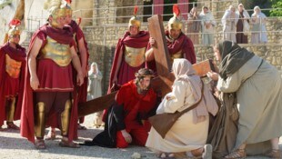 Die Frauen leisten Jesus, der unter der Last des Kreuzes zusammenbricht, Beistand.