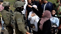 Palästinenser, die zu ihren Feldern im Westjordanland wollen, werden von israelischen Soldaten ...