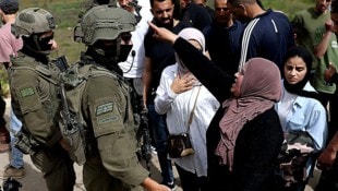 Palästinenser, die zu ihren Feldern im Westjordanland wollen, werden von israelischen Soldaten ...