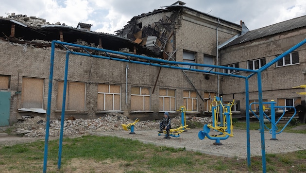 Ein Kind auf dem Spielplatz einer zerstörten Schule in Kramatorsk im ukrainisch kontrollierten ...