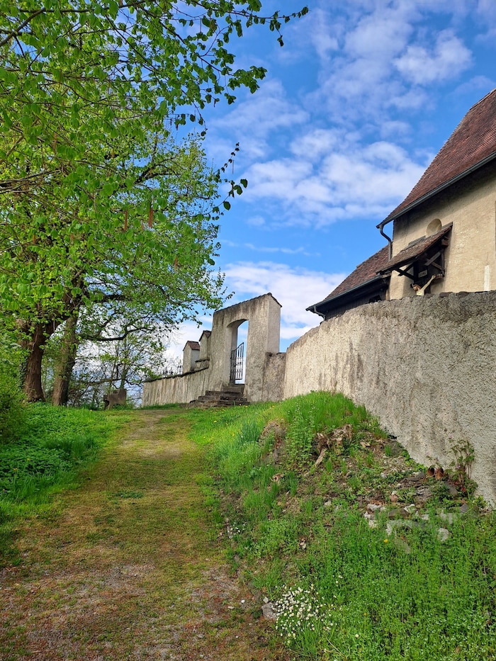 Pfad entlang der Kirchenmauer.