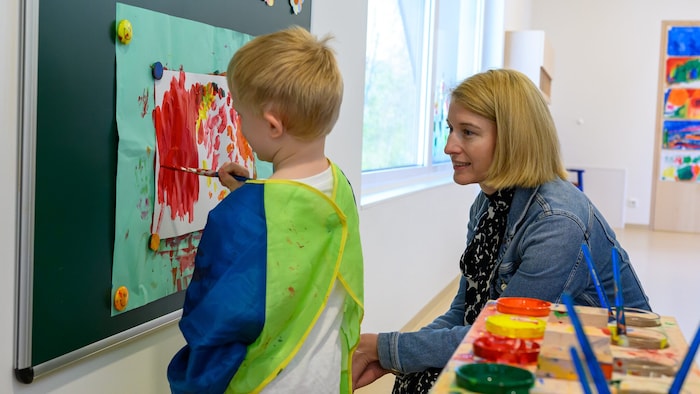Haberlander blickt im Kindergarten Oberndorf einem Nachwuchskünstler über die Schultern.