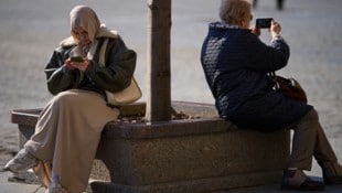 Zwei Frauen mit ihren Smartphones in Moskau