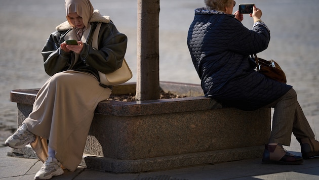 Zwei Frauen mit ihren Smartphones in Moskau