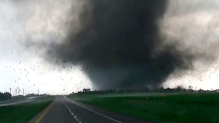 In Aufnahmen von Storm Chasern ist ein riesiger, schwarzgrauer Tornado-Trichter zu sehen.