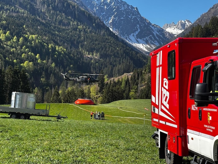 Ein Bundesheer-Hubschrauber holt sich Löschwasser (im Hintergrund).