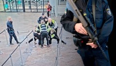Die Polizistin steht daneben, während ihr Kollege mit dem Täter um das Sturmgewehr mit 30 Schuss ...
