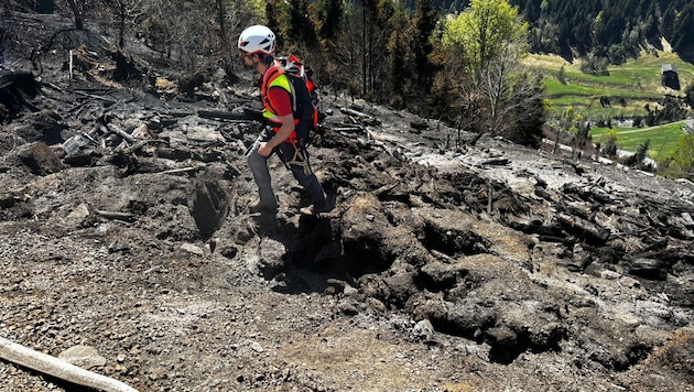 Bergretter sichern Feuerwehren während der Bekämpfung von Glutnestern in dem steilen Gelände des ...