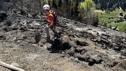 Bergretter sichern Feuerwehren während der Bekämpfung von Glutnestern in dem steilen Gelände des ...