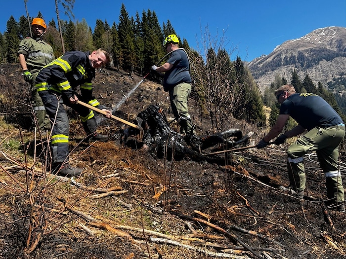 Mühevoll werden einzelne Baumstümpfe herausgehackt, um zu den Brandherden zu gelangen.