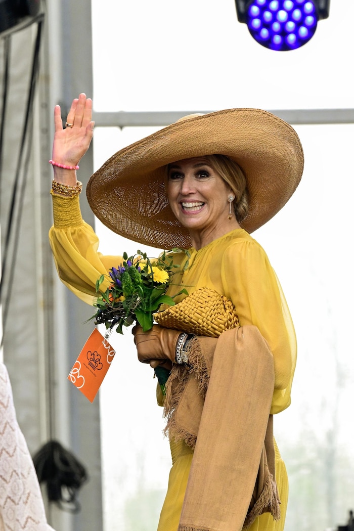 Die Königin winkte in einem gelben Kleid – dazu hatte sie einen großkrempigen Hut kombiniert.
