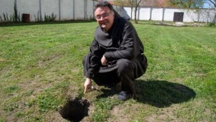 Pater Thomas Lackner bei dem Loch in der Wiese neben der Basilika. 