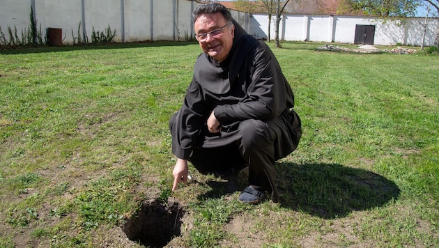 Pater Thomas Lackner bei dem Loch in der Wiese neben der Basilika.