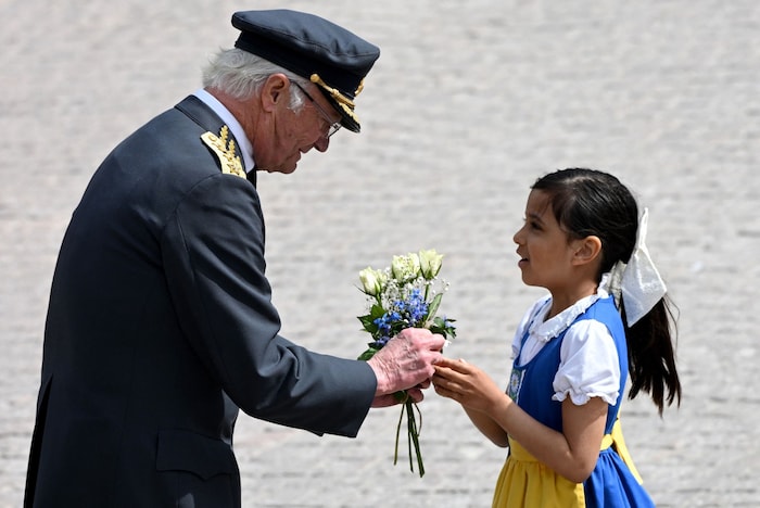 Der König bekommt von einem Mädchen Blumen überreicht.