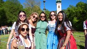 Dirndl-Pracht vor Kirche und Maibaum in Aigen
