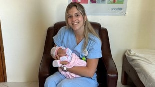 Laura Müller mit einem neugeborenen Baby während ihres Praktikums auf den Philippinen