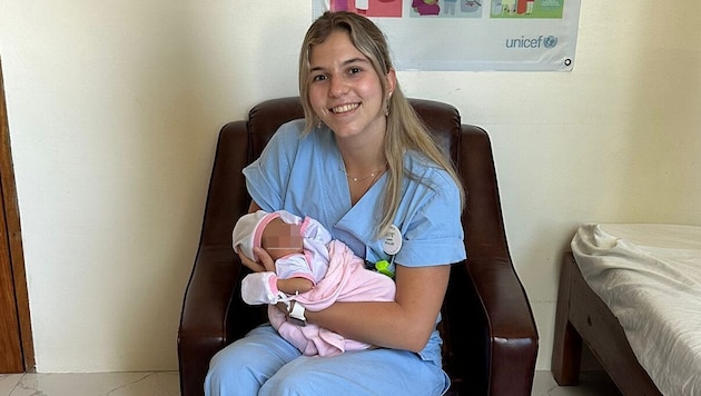 Laura Müller mit einem neugeborenen Baby während ihres Praktikums auf den Philippinen