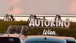 Rosarote Abendsonne über den Autodächern  – erst nach Sonneruntergang kann der Film beginnen – ...
