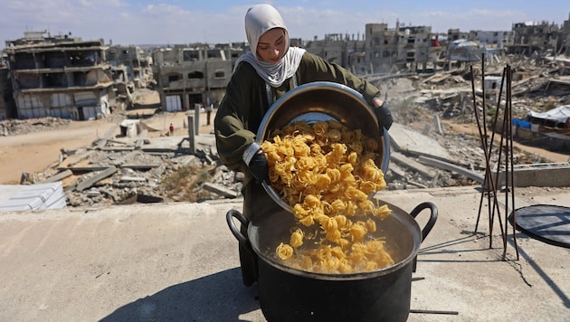Eine Frau kocht auf dem Dach ihres Hauses in Gaza, um bedürftige Kinder mit einer Mahlzeit zu ...