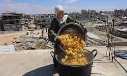 Eine Frau kocht auf dem Dach ihres Hauses in Gaza, um bedürftige Kinder mit einer Mahlzeit zu ...