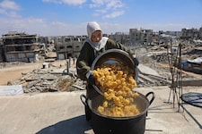 Eine Frau kocht auf dem Dach ihres Hauses in Gaza, um bedürftige Kinder mit einer Mahlzeit zu ...