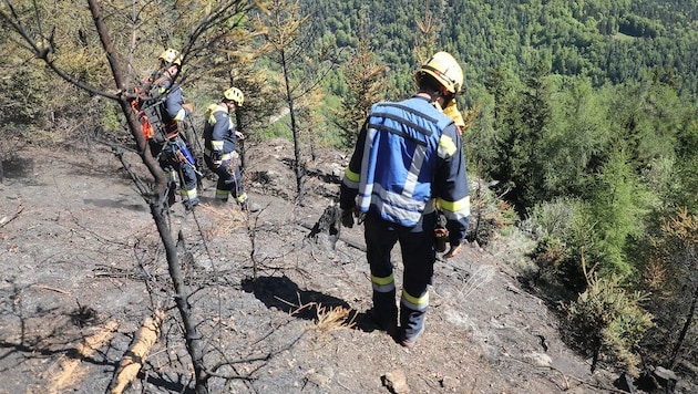 Im steilen Gelände suchen die Einsatzkräfte nach Glutnestern.