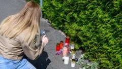 Kerzen und Blumen erinnern an der Hecke beim Gasthaus-Parkplatz an die grausige Bluttat mit drei ...