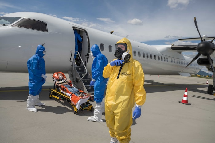 Die erste Ebola-Patientin, die aus dem Flugzeug gebracht wurde, wird am Rollfeld erstversorgt ...