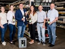 Philipp Haderer (Mitte) präsentiert mit der Steuerungsgruppe die neuen Pfandflaschen für ...