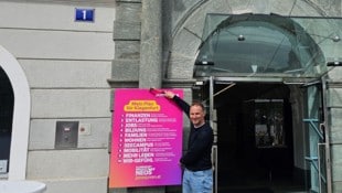 Janos Juvan heftet seine zehn Forderungen für die Stadt Klagenfurt fest an das Rathaustor.