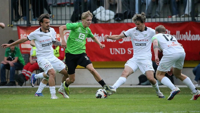 Grünaus Wildmann (grün) im Duell mit drei Eugendorfern.