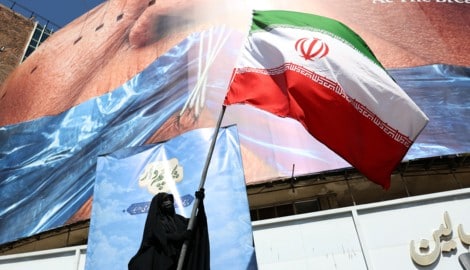 Eine Regime-Unterstützerin schwenkt die iranische Flagge in Teheran.