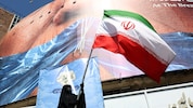 Eine Regime-Unterstützerin schwenkt die iranische Flagge in Teheran.