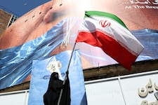 Eine Regime-Unterstützerin schwenkt die iranische Flagge in Teheran.