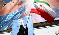Eine Regime-Unterstützerin schwenkt die iranische Flagge in Teheran.
