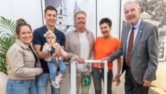 Bürgermeister Klaus Schneeberger (re.) übergab das Fenster samt buntem Fisch an Familie Tremmel.