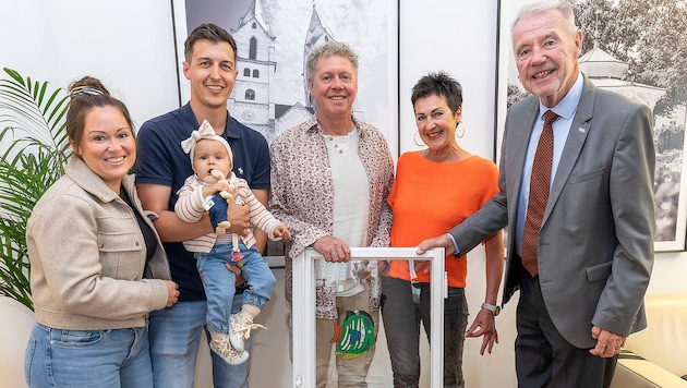 Bürgermeister Klaus Schneeberger (re.) übergab das Fenster samt buntem Fisch an Familie Tremmel.